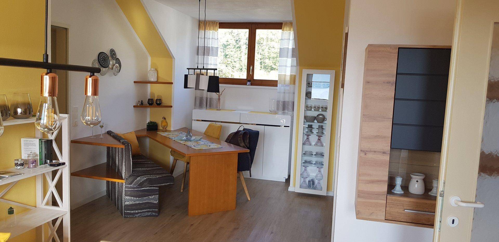 Geräumiger Essbereich mit Holztisch und Blick in den angrenzenden Wohnbereich.