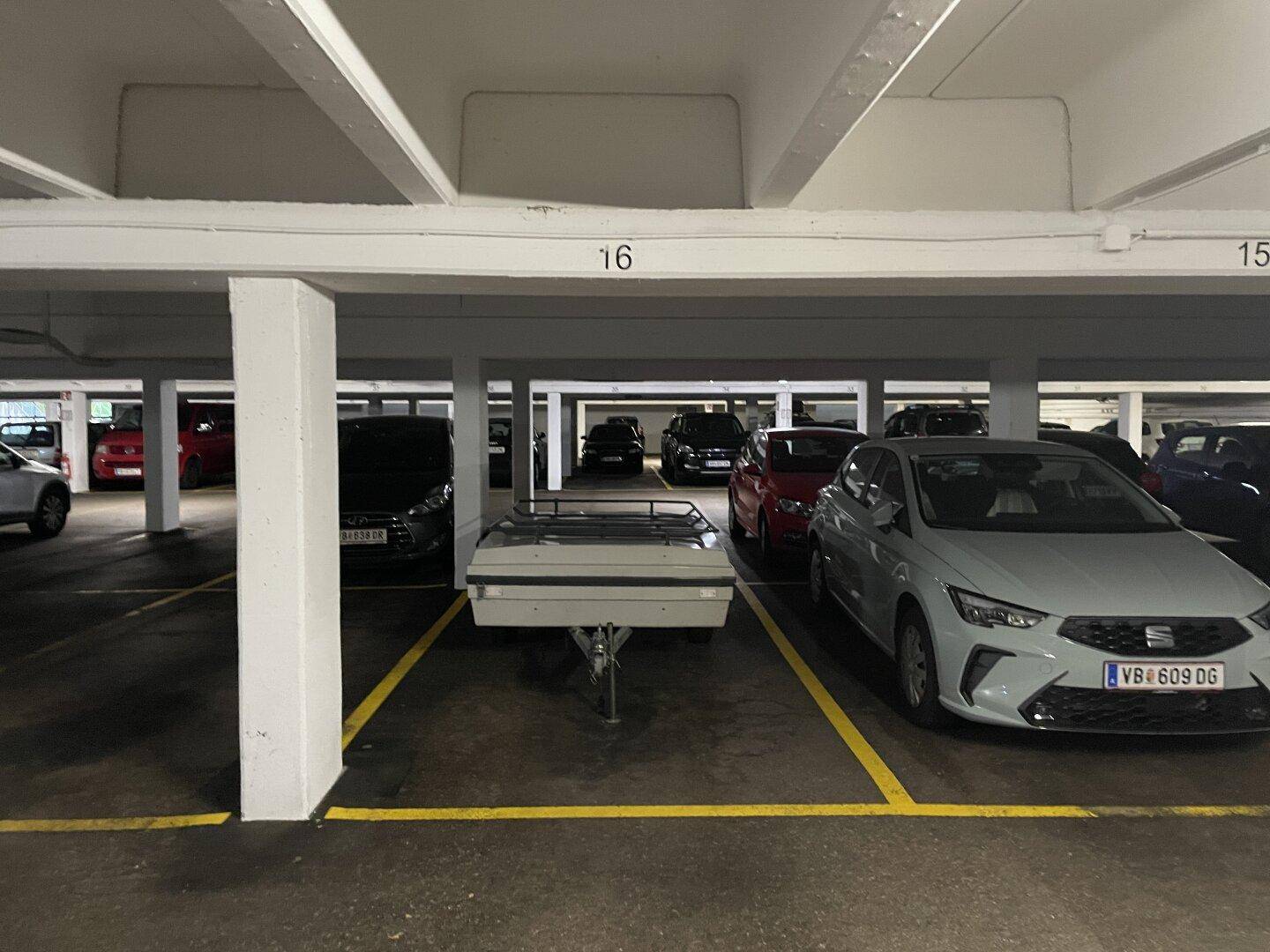 Tiefgarage mit mehreren Stellplätzen und einem Anhänger.