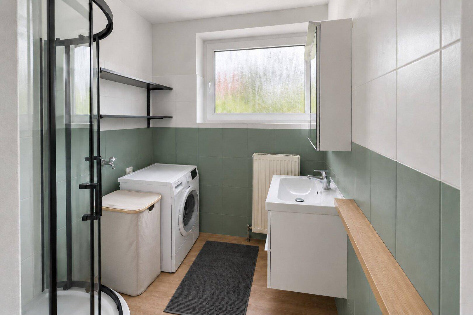 Modernes Badezimmer mit Duschkabine, Waschbecken, Waschmaschine und Fenster.
