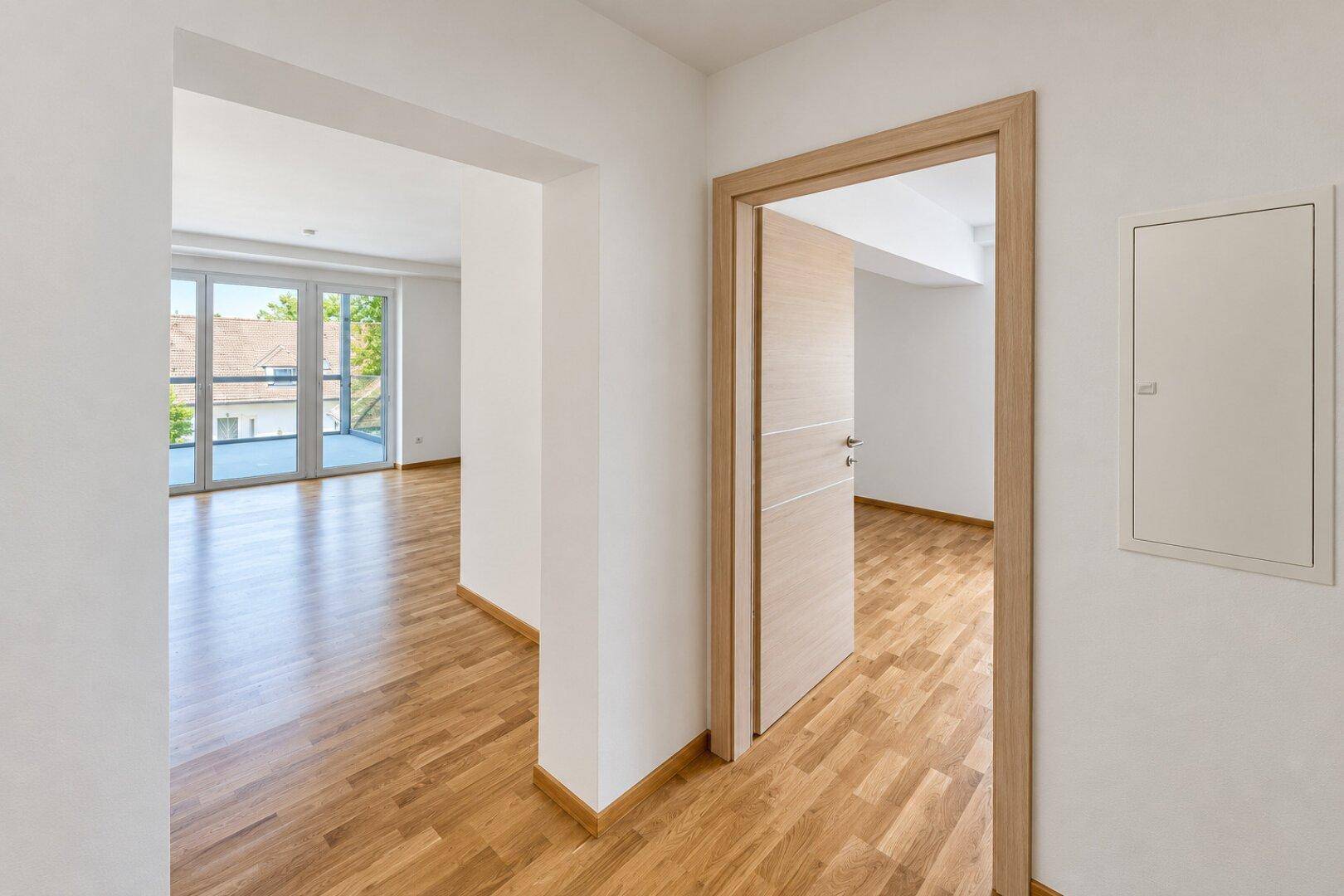 Heller Flur mit Parkettboden und Zugang zu weiteren Räumen der Wohnung.