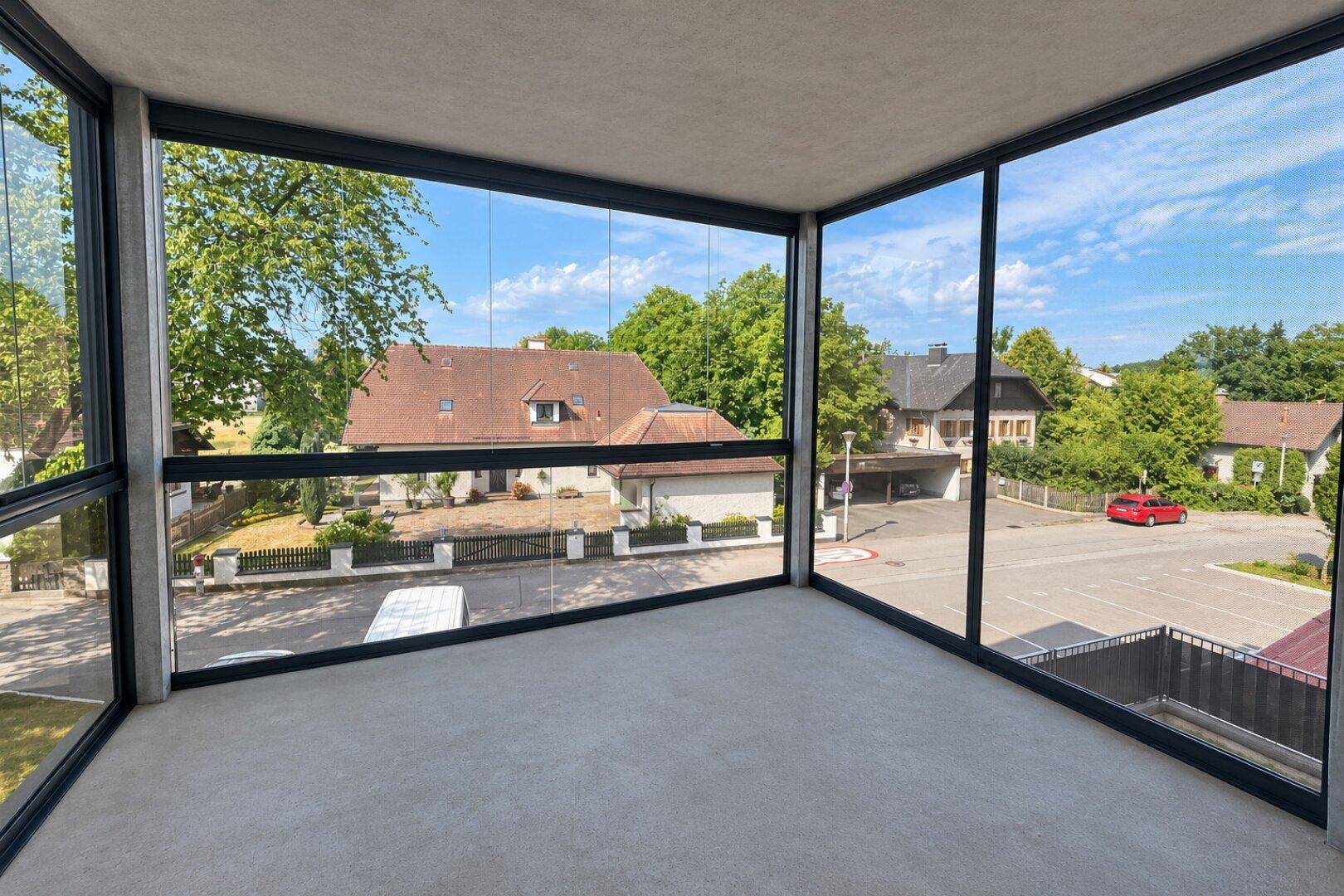 Verglaster Balkon mit weitem Blick über die Nachbarschaft und viel Tageslicht.