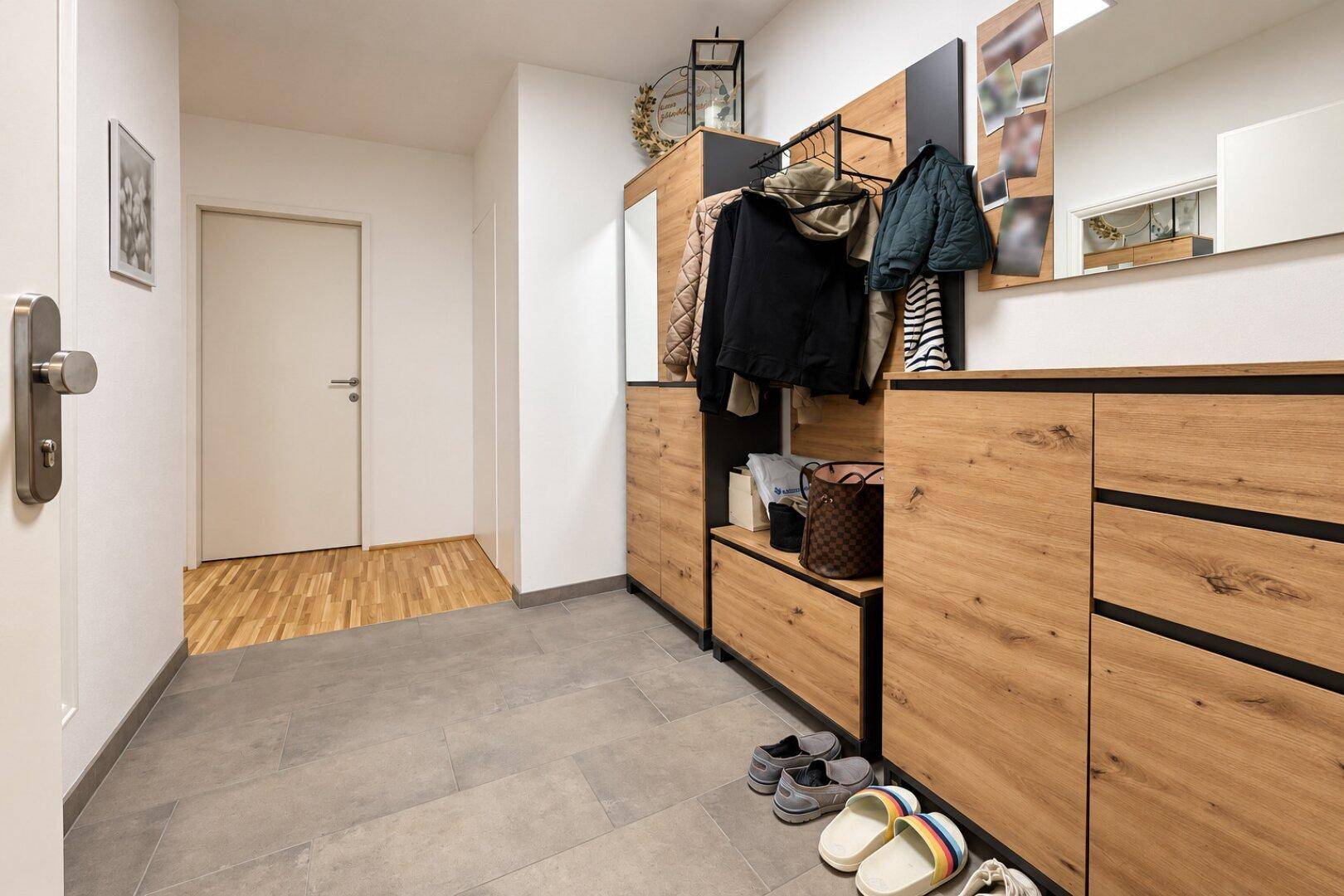 Geräumiger Flur mit praktischen Holzschränken und Ablagemöglichkeiten, ideal für den Eingangsbereich.