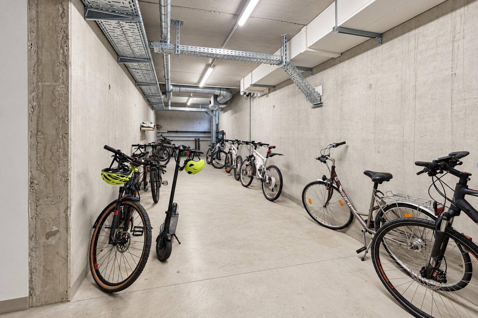 Geräumiger Fahrradraum im Untergeschoss mit vielen Abstellmöglichkeiten für Fahrräder und Roller.