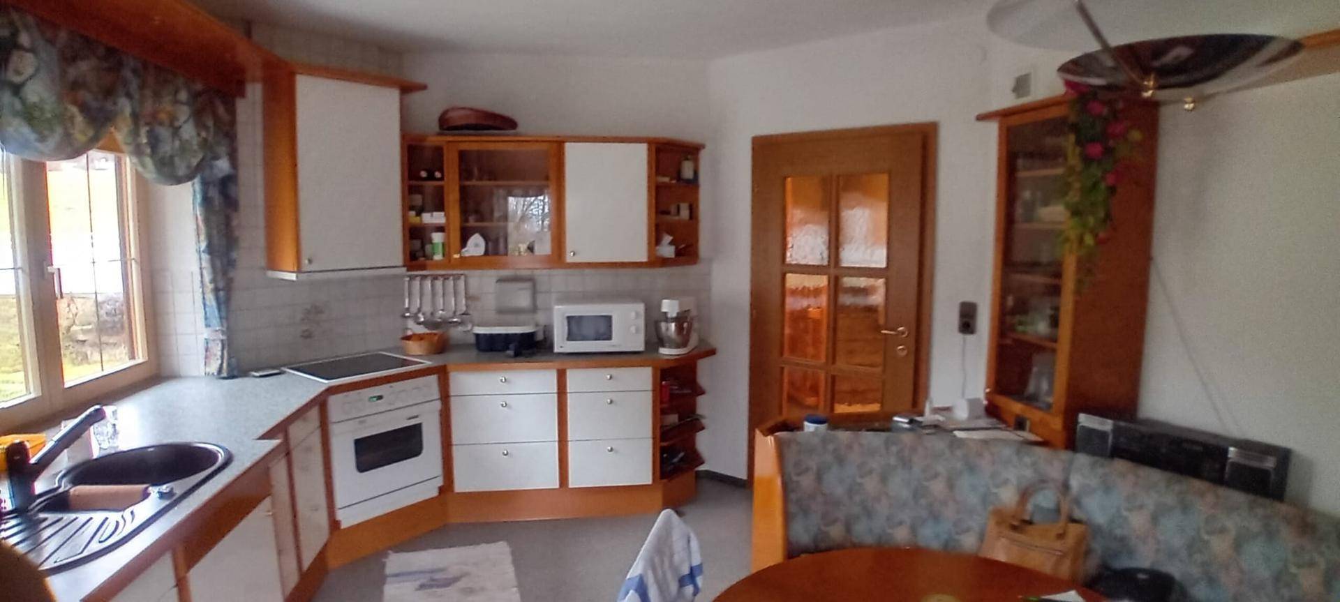 Gemütliche Wohnküche im traditionellen Stil mit Holzelementen und einer Eckbank.