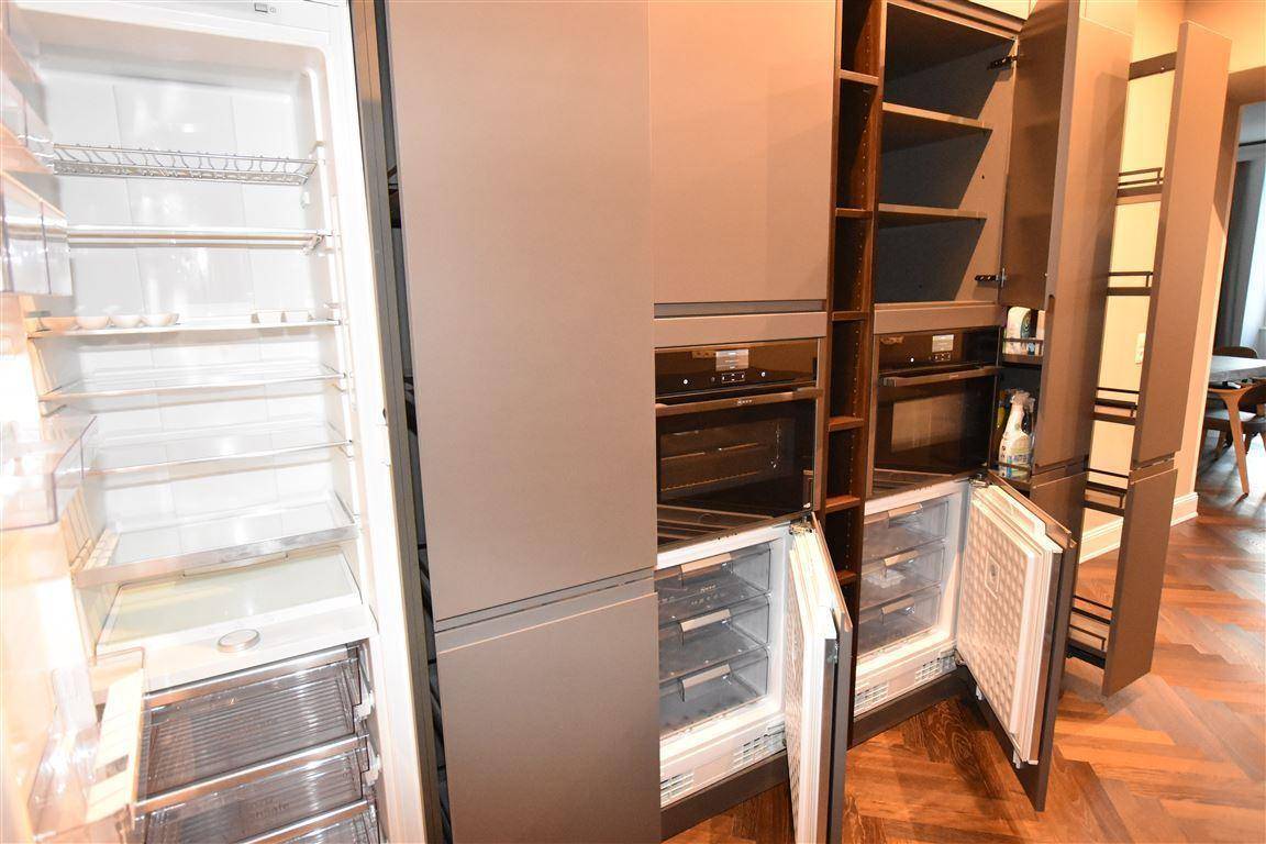 Moderne Küche mit integriertem Kühlschrank, Gefrierschrank und zwei Backöfen.