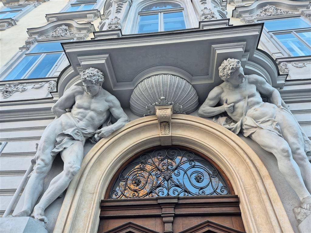 Prunkvolle Fassade eines historischen Gebäudes mit klassischen Statuen und Verzierungen.