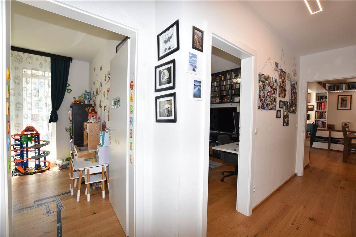 Heller Flur mit Holzboden und Zugängen zu verschiedenen Zimmern der Wohnung.