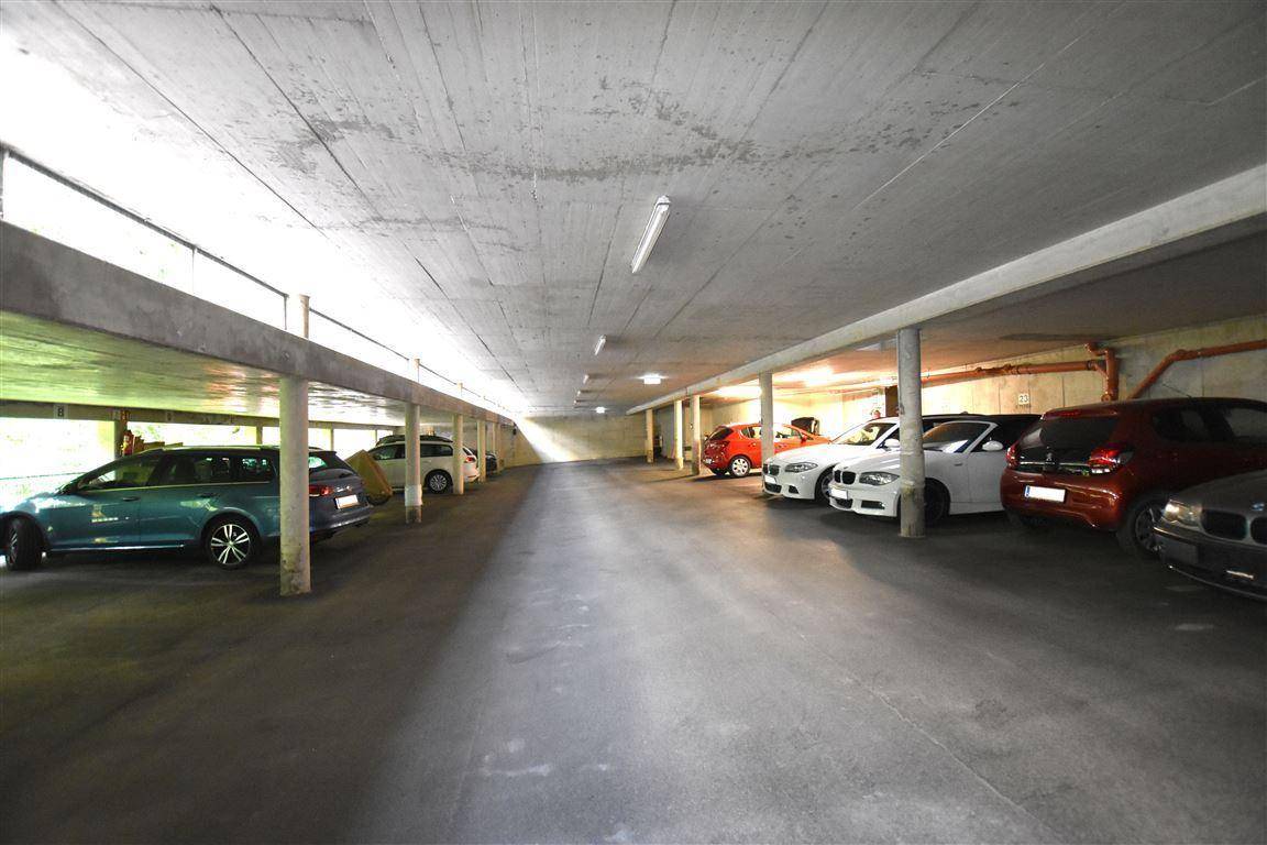 Tiefgarage mit zahlreichen Stellplätzen und Betonkonstruktion, gut beleuchtet.
