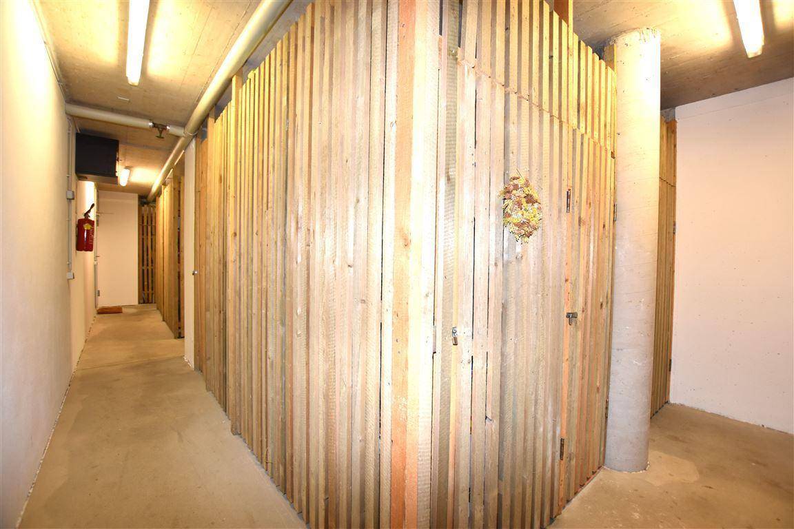 Kellerabteilbereich mit Holzverschlägen für individuellen Stauraum und Betonboden.