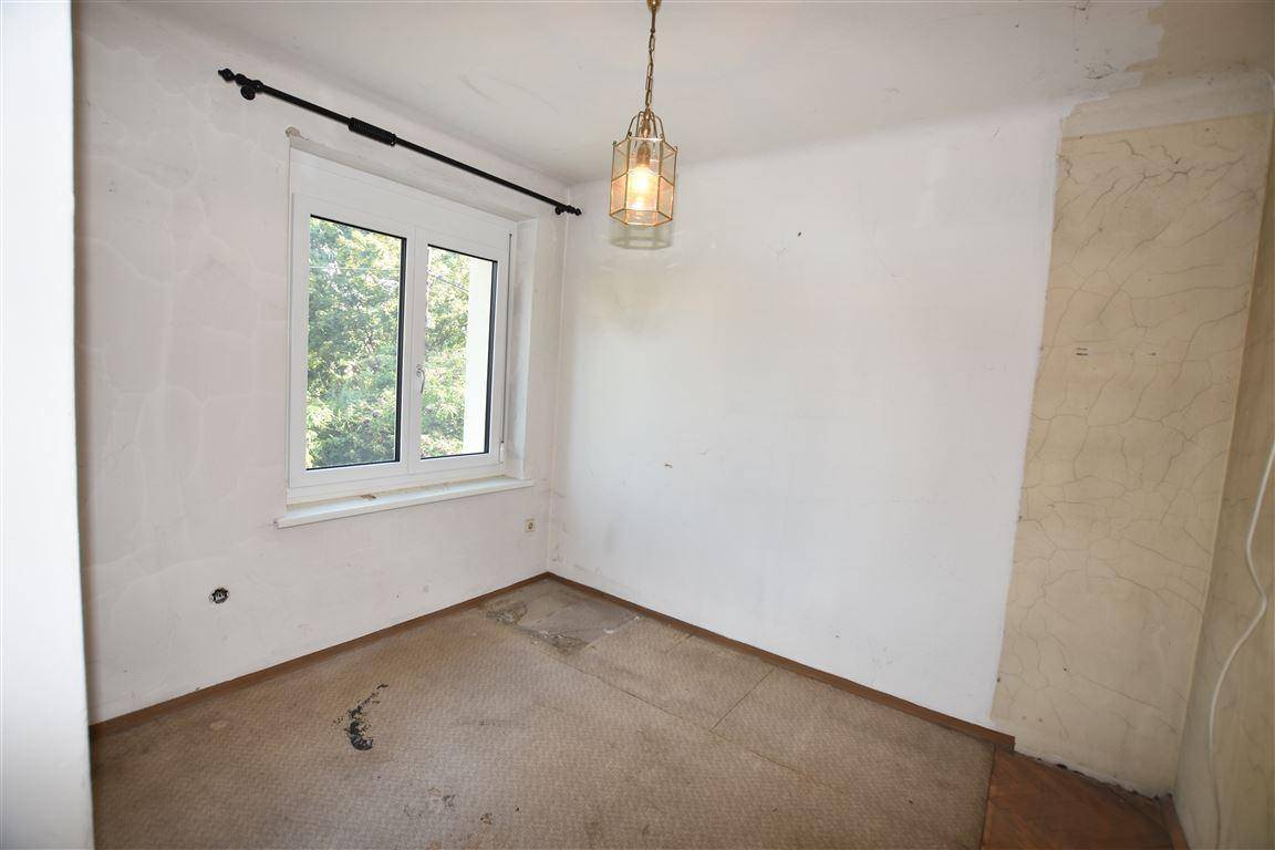 Kleines Zimmer mit Teppichboden und Fenster, ideal als Kinder- oder Arbeitszimmer.