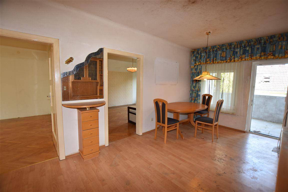 Essbereich mit Holztisch und Stühlen, Parkettboden und Zugang zu weiteren Räumen sowie einem Außenbereich.