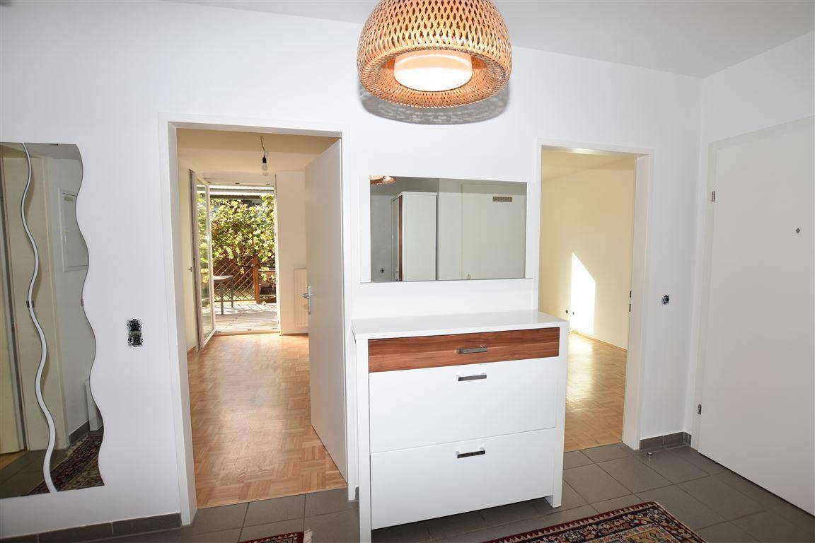 Heller Flur mit Kommode und offenem Zugang zu den Wohnbereichen.