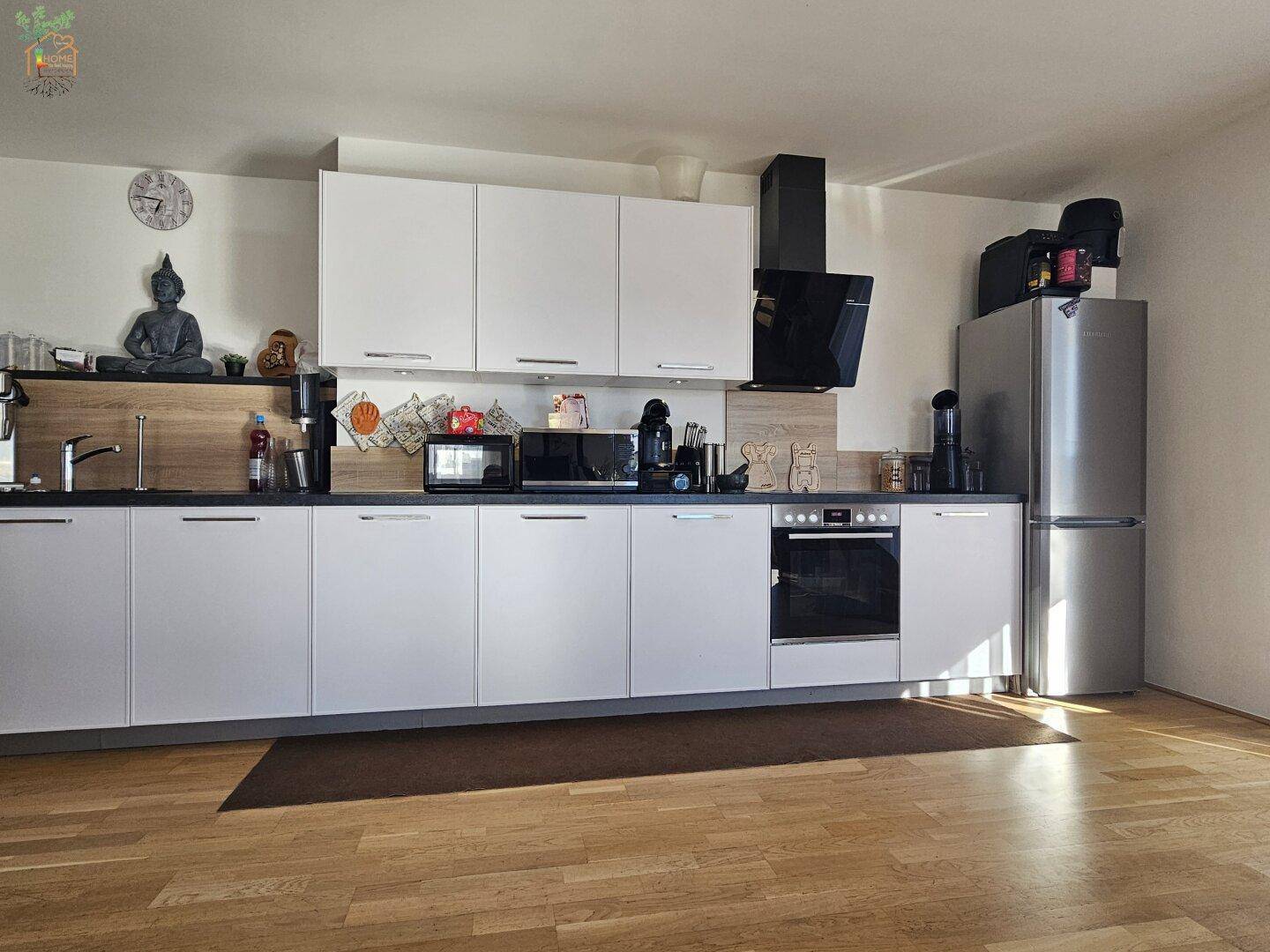 Geräumige, moderne Küche mit viel Stauraum, weißen Fronten und einem großen Kühlschrank.