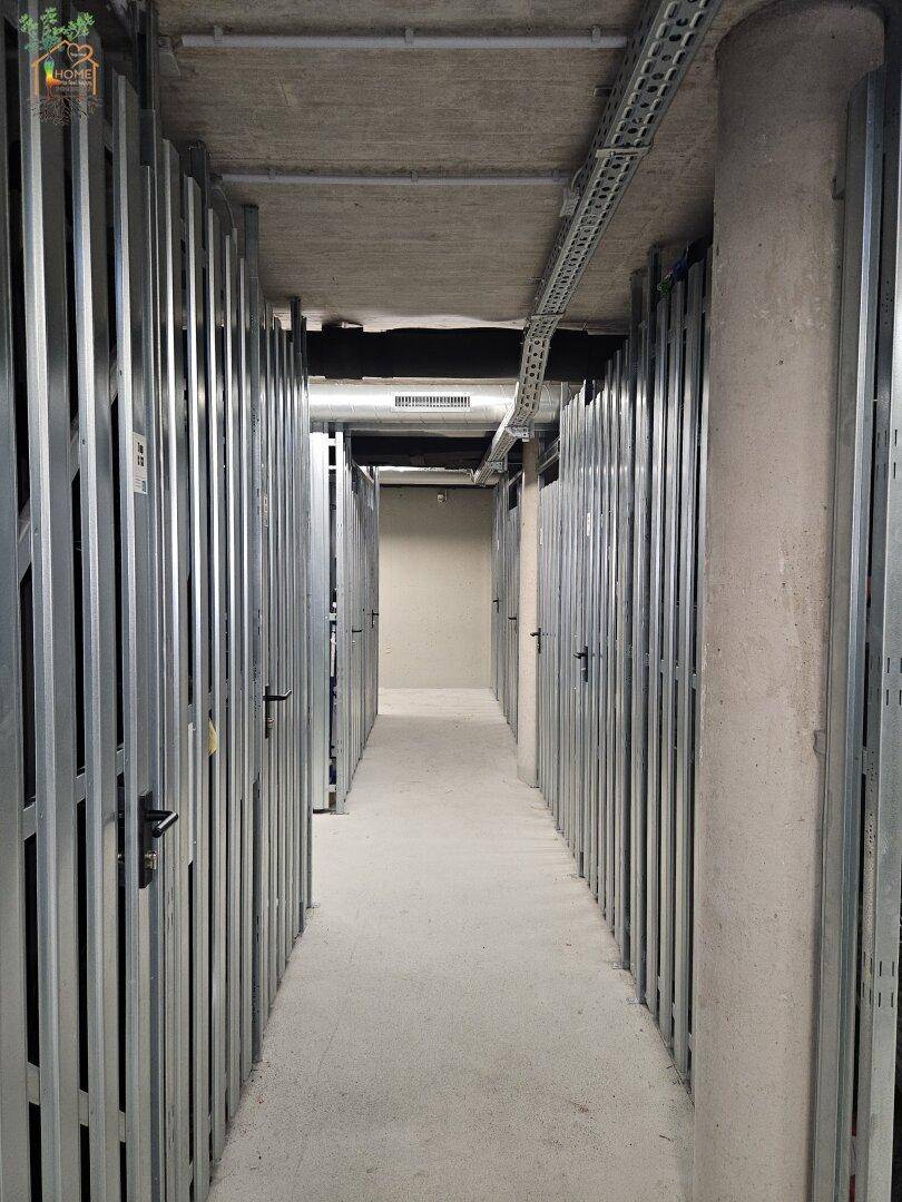 Geräumiger Abstellraum im Keller mit individuellen Lagerabteilen und Betonboden.