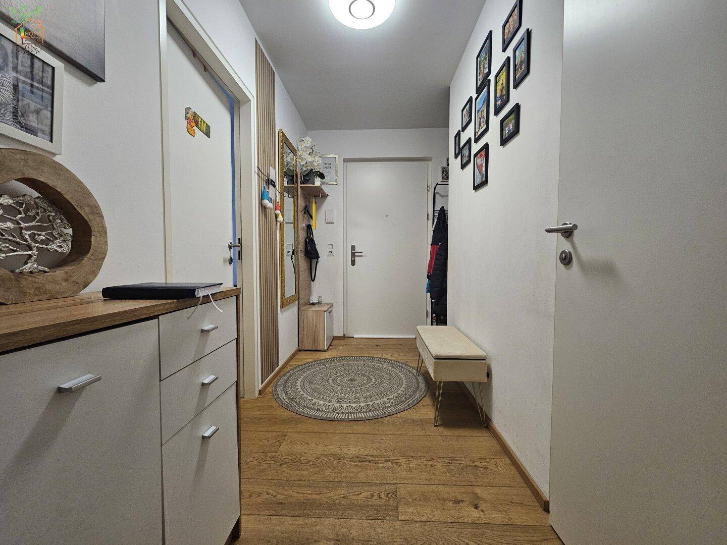 Einladender Flur mit Holzboden, Garderobe und dekorativen Elementen.