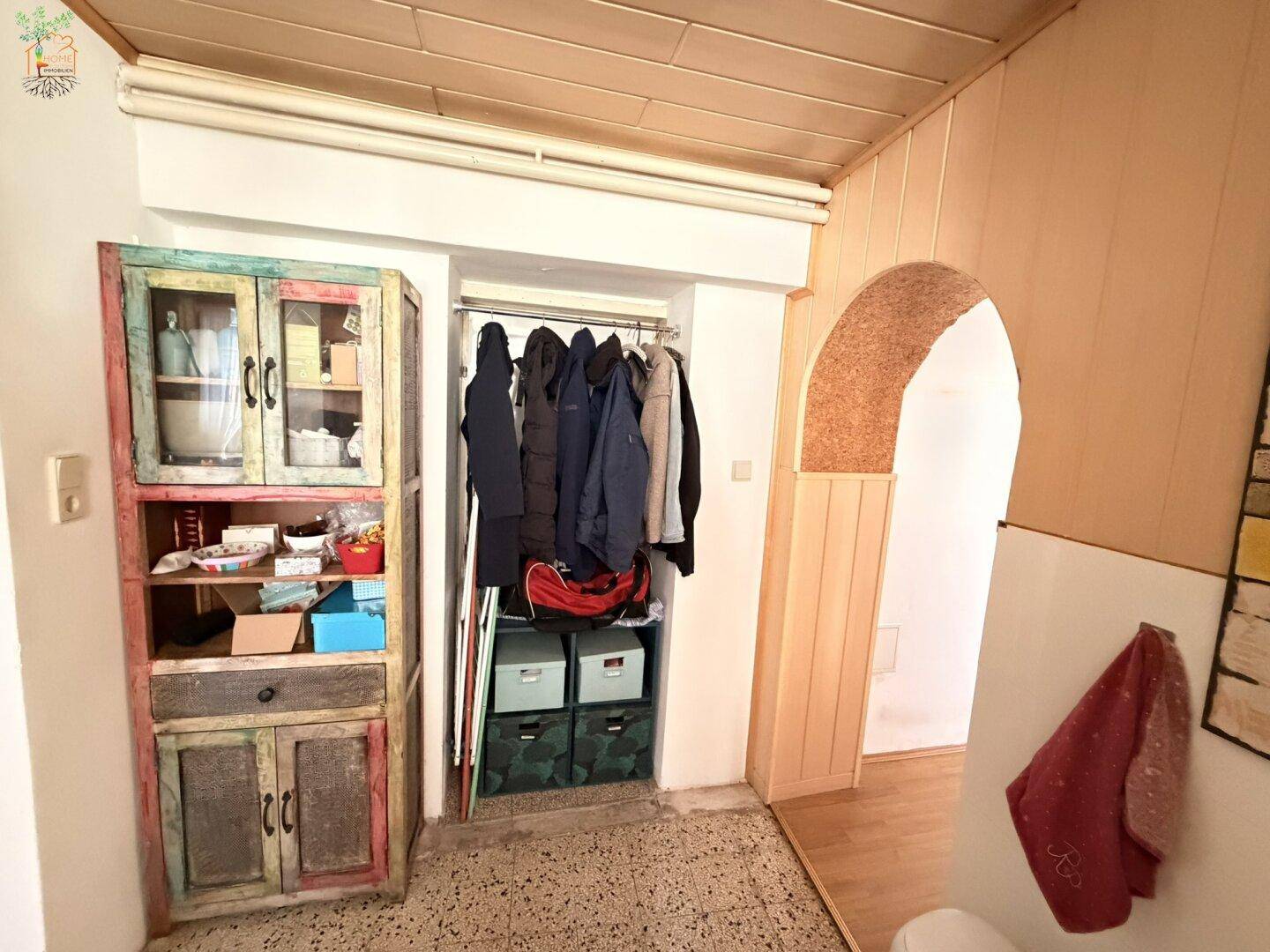 Flur mit farbenfrohem Schrank, Garderobe und einem charmanten Bogendurchgang.