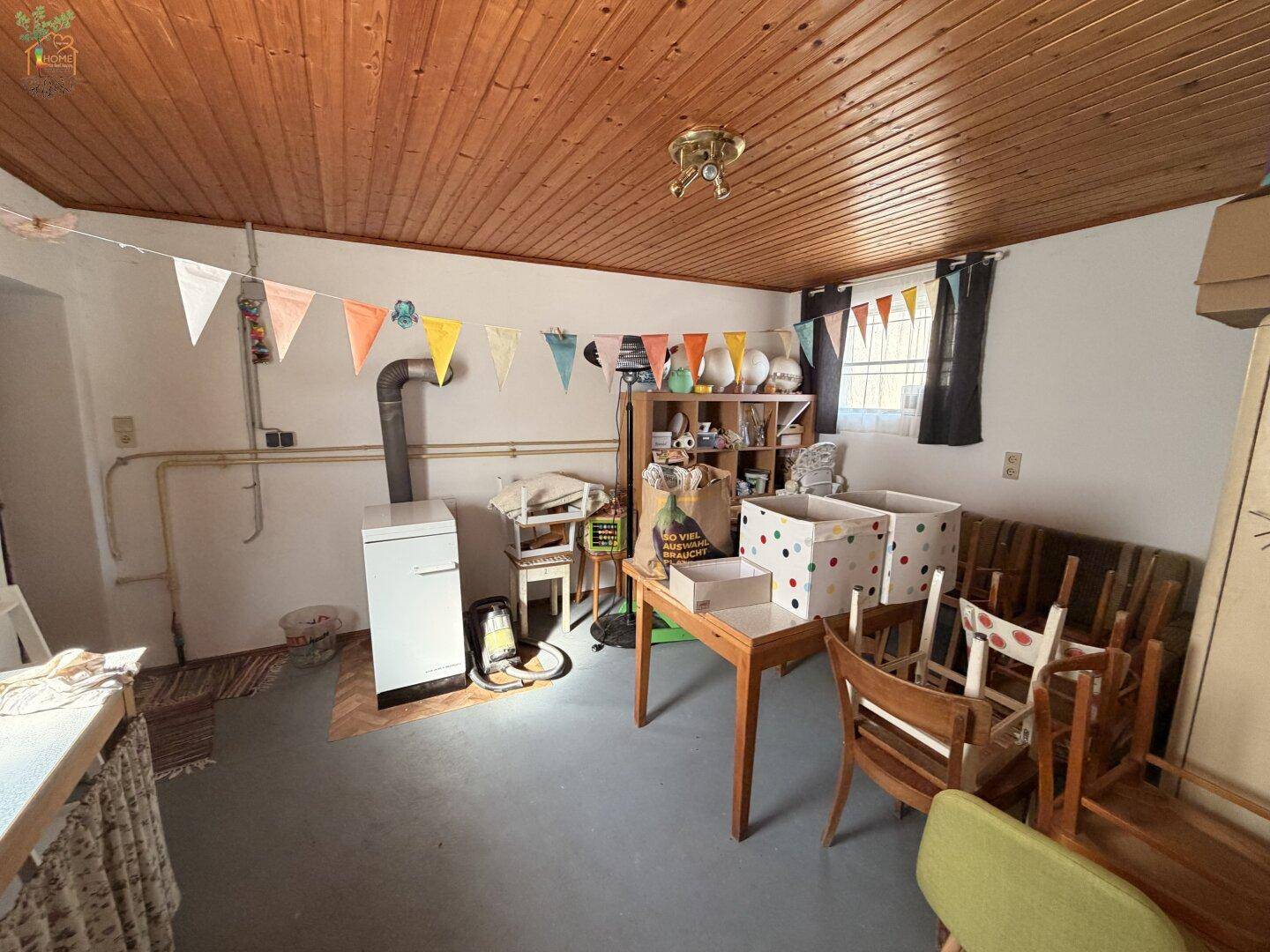 Rustikaler Kellerraum mit Holzofen, Stauraum und Holzdecke, vielseitig nutzbar.