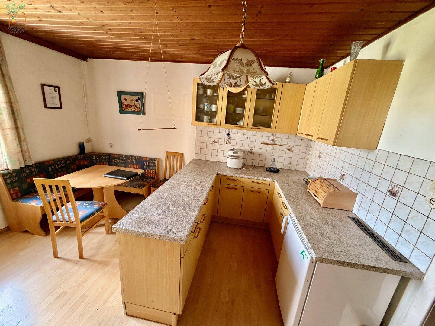 Traditionelle Küche mit Holzeinbauten, Essbereich und gefliesten Wänden im Landhausstil.