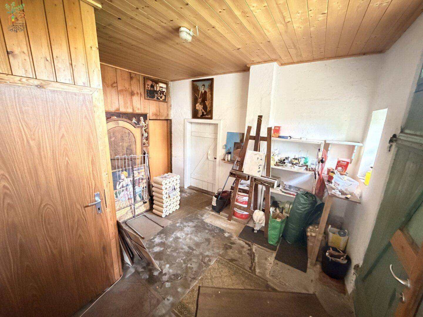 Abstellraum oder Werkstatt mit Holzboden und verschiedenen Utensilien.