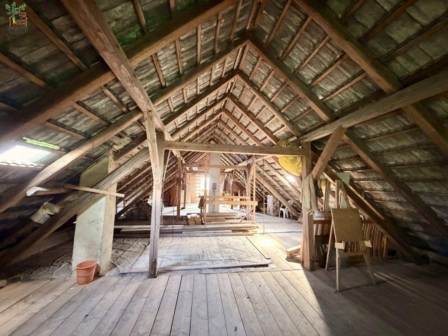 Geräumiger Dachboden mit sichtbarer Holzkonstruktion und Holzboden, bereit zum Ausbau.