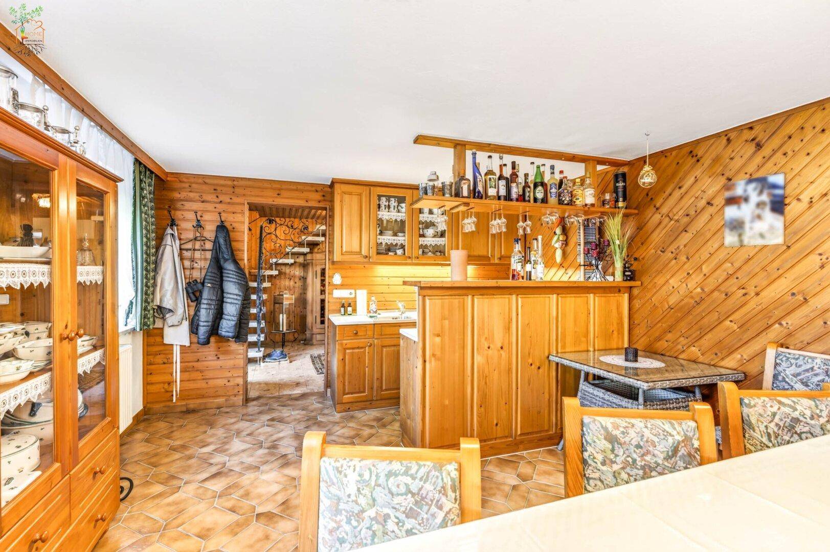 Rustikaler Essbereich mit Holzvertäfelung, integrierter Bar und gefliestem Boden.