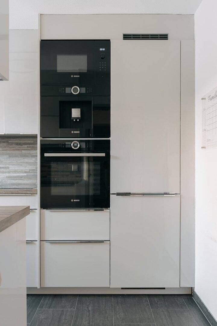 Integrierte Küchenzeile mit Bosch-Einbaugeräten, darunter Backofen, Mikrowelle und Kühlschrank.