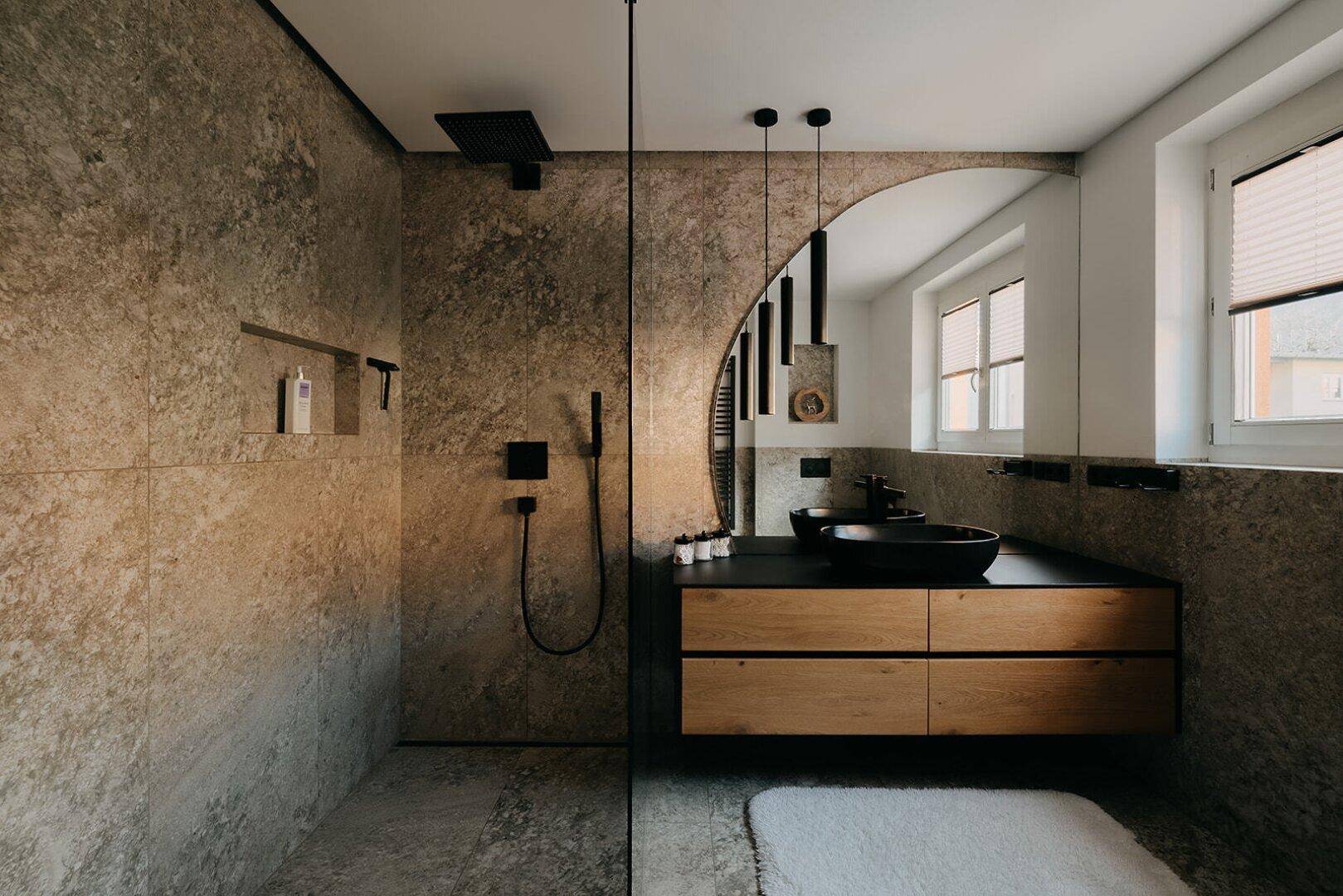 Modernes Badezimmer mit begehbarer Dusche, Natursteinfliesen und stilvollem Holzwaschtisch.