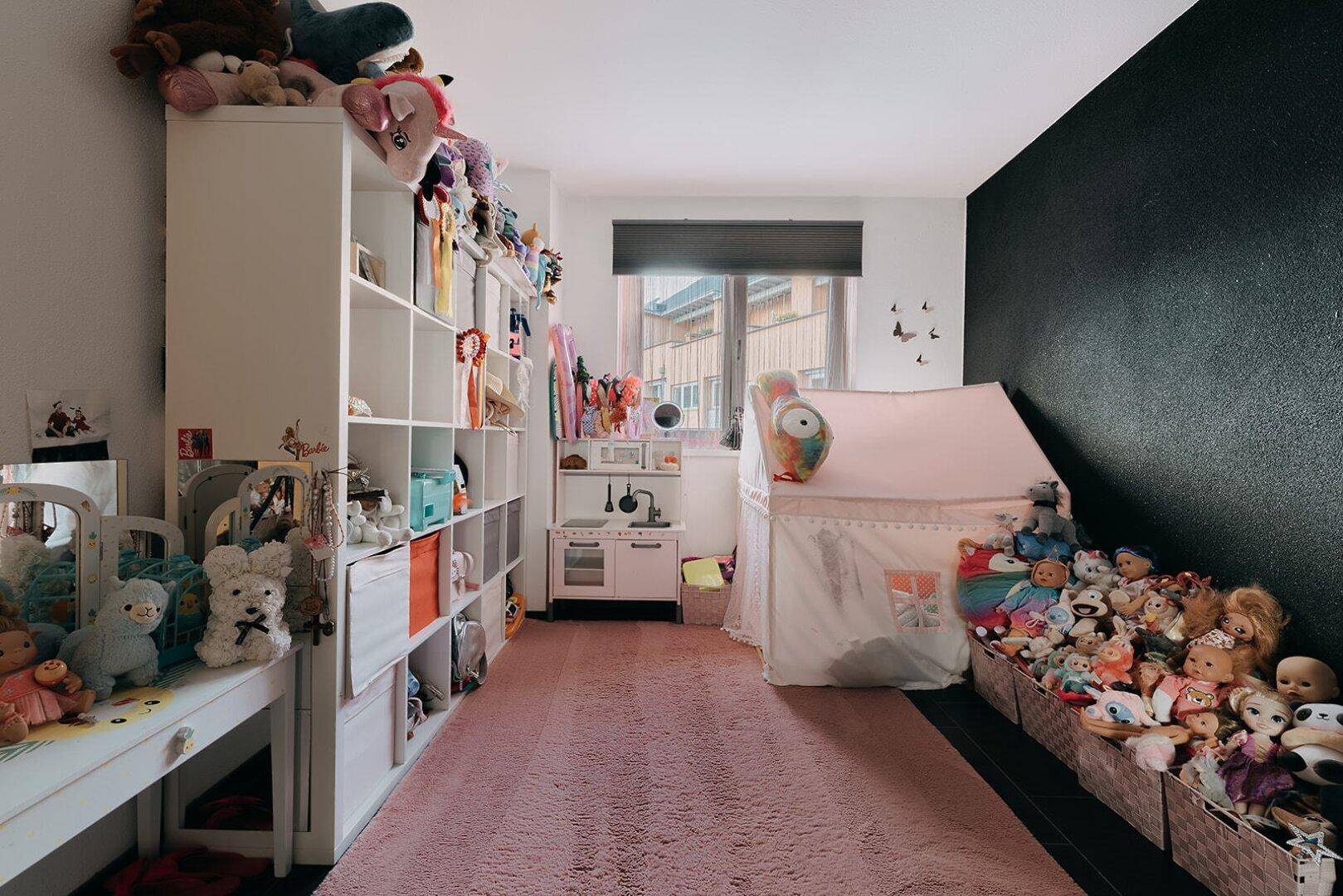 Kinderzimmer mit Spielzeug, Regalen und einem Spielzelt, ideal für kleine Bewohner.