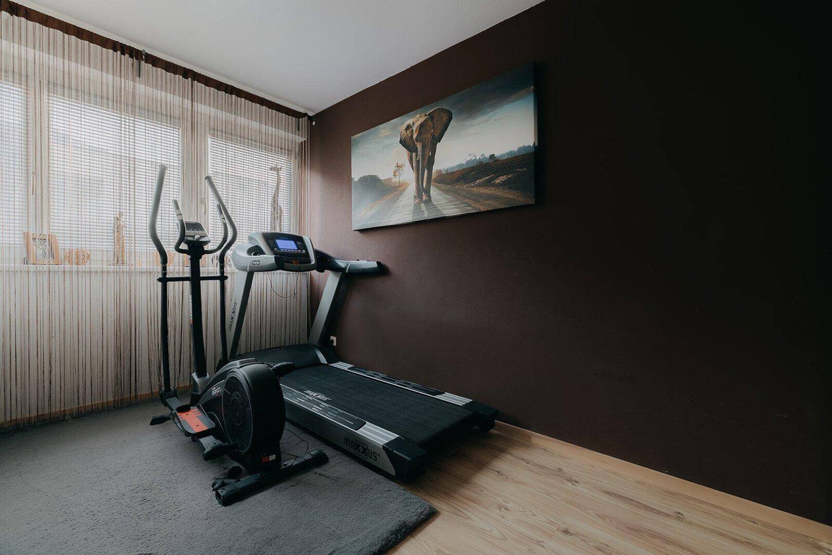 Fitnessraum mit Laufband und Crosstrainer, ideal für das Training zu Hause.
