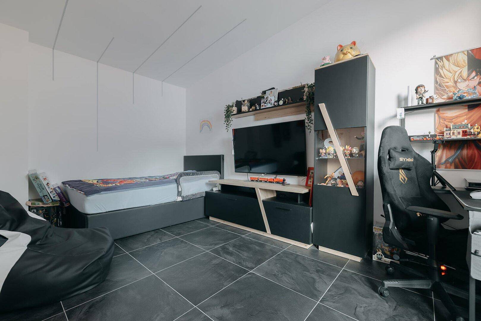 Jugendzimmer mit modernem Bett, Schreibtisch und Gaming-Stuhl, ideal für Teenager.