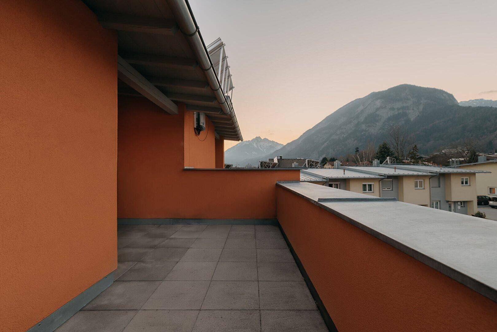 Große Dachterrasse mit Fliesenboden und weitem Blick auf die Berge und Umgebung.