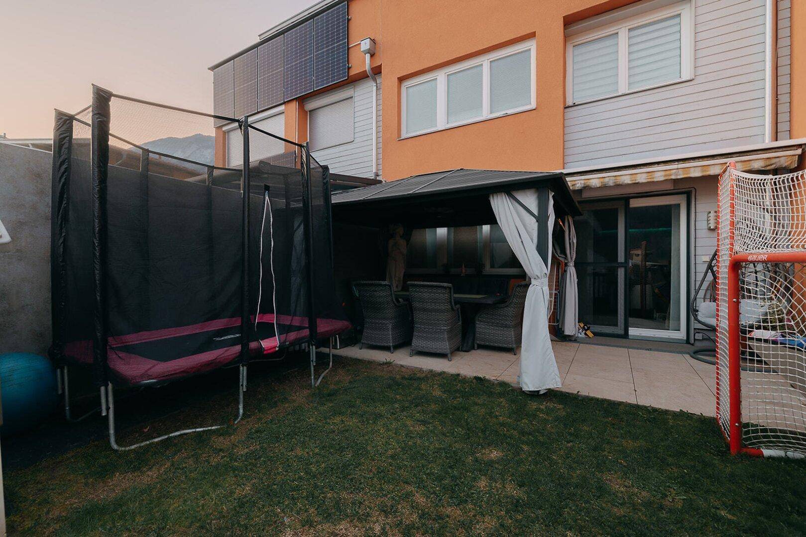 Gartenbereich mit Trampolin, Grillplatz und Spieltor, ideal für Familienaktivitäten.
