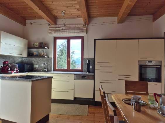 Helle Küche mit Essbereich, integrierten Geräten und Fenster mit weitem Blick in die Landschaft.