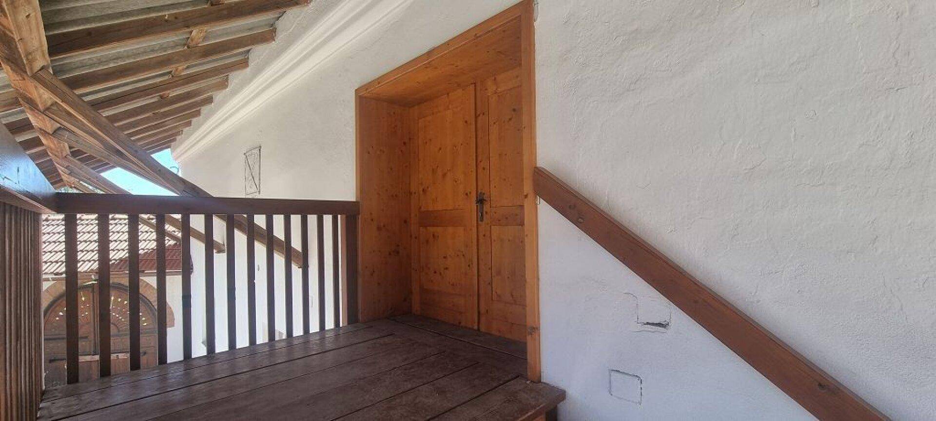 Dachbodenbereich mit Holzgeländer und sichtbarer Dachkonstruktion, bereit für Ausbau.