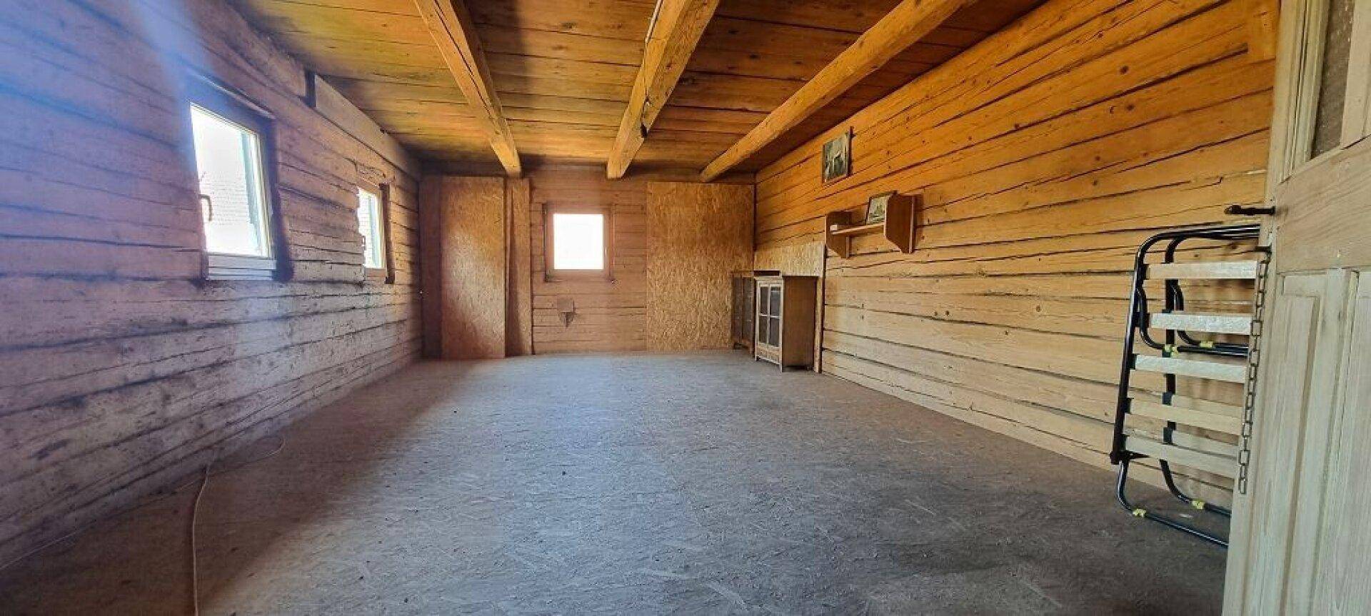 Rustikaler, leerer Raum mit Holzwänden und -decke, bereit für individuelle Gestaltung.