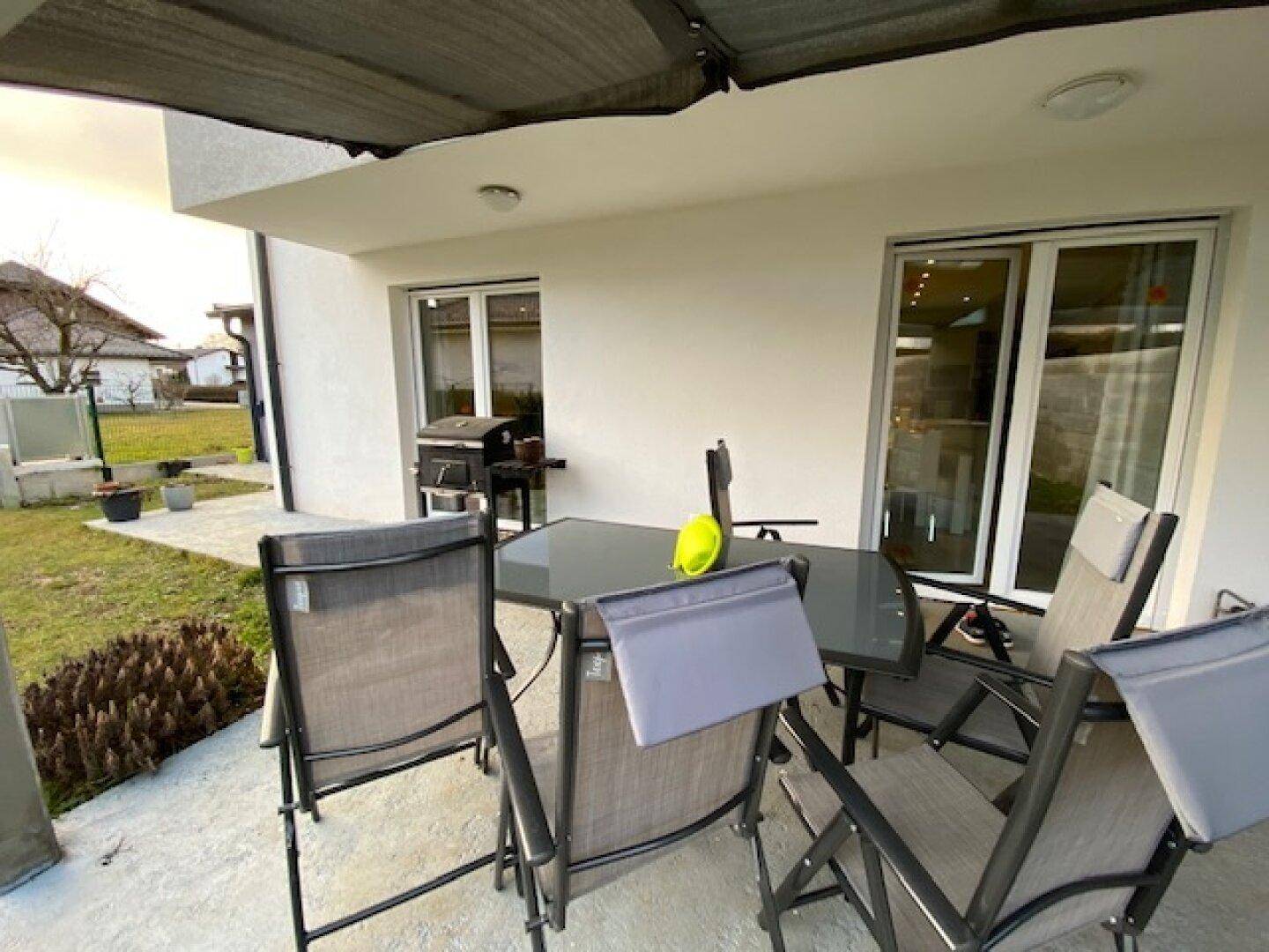 Geräumige Terrasse mit Gartenmöbeln und Grillbereich, ideal für entspannte Stunden im Freien.