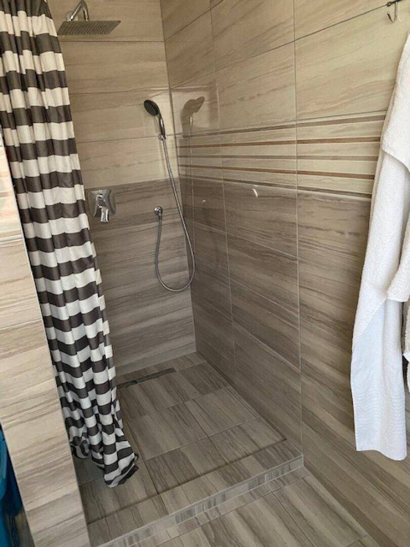Duschbereich im Badezimmer mit modernen Fliesen und einer praktischen Duschvorhanglösung.