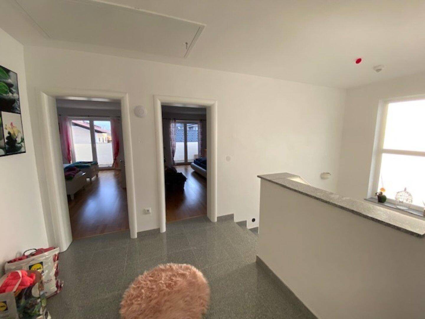 Geräumiger Flur mit Treppenaufgang und Zugang zu mehreren Zimmern, hell und einladend gestaltet.