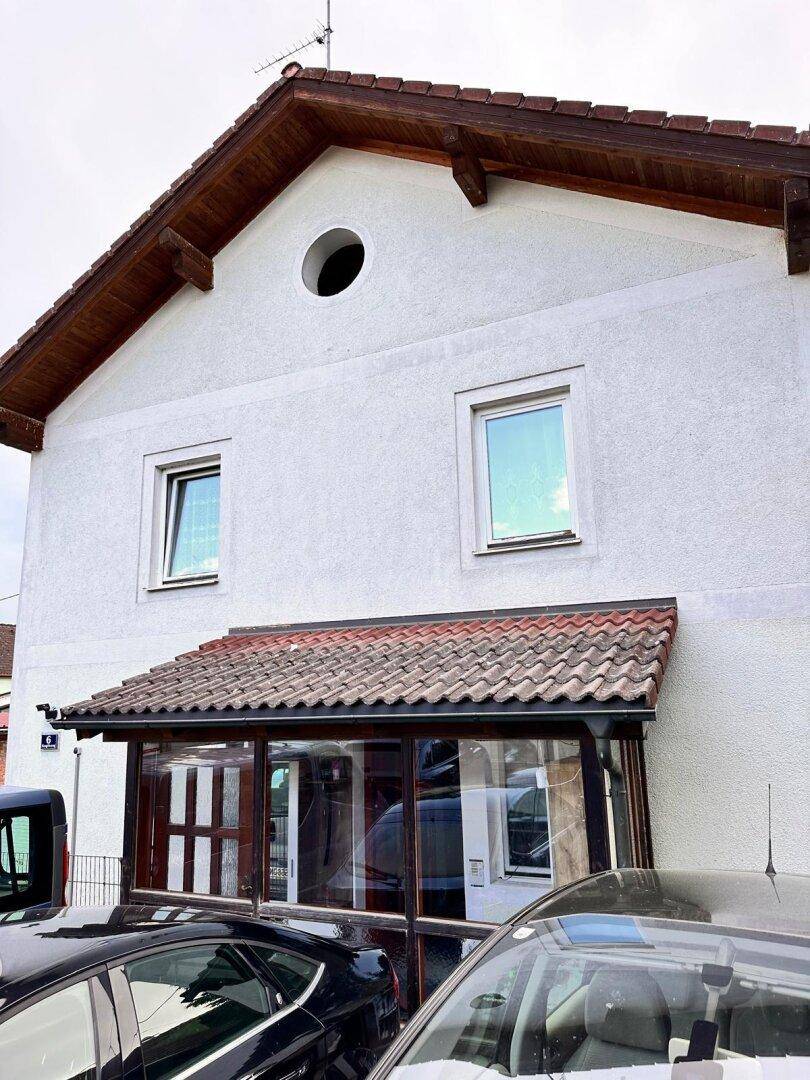 Fassade des Hauses mit überdachtem Eingangsbereich und Fenstern.