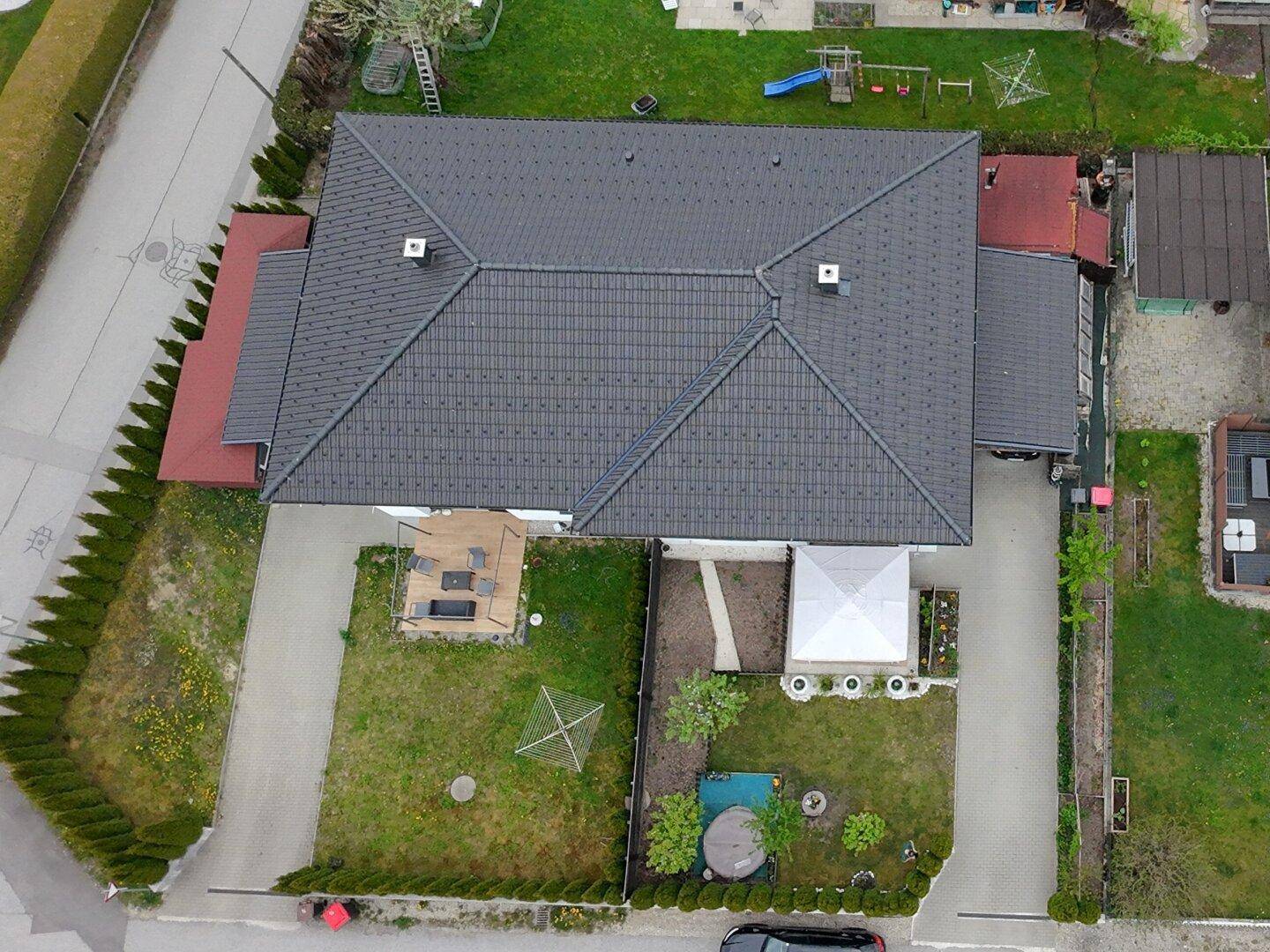 Luftaufnahme des Hauses mit Satteldach, Gartenbereich und umliegender Wohnbebauung.