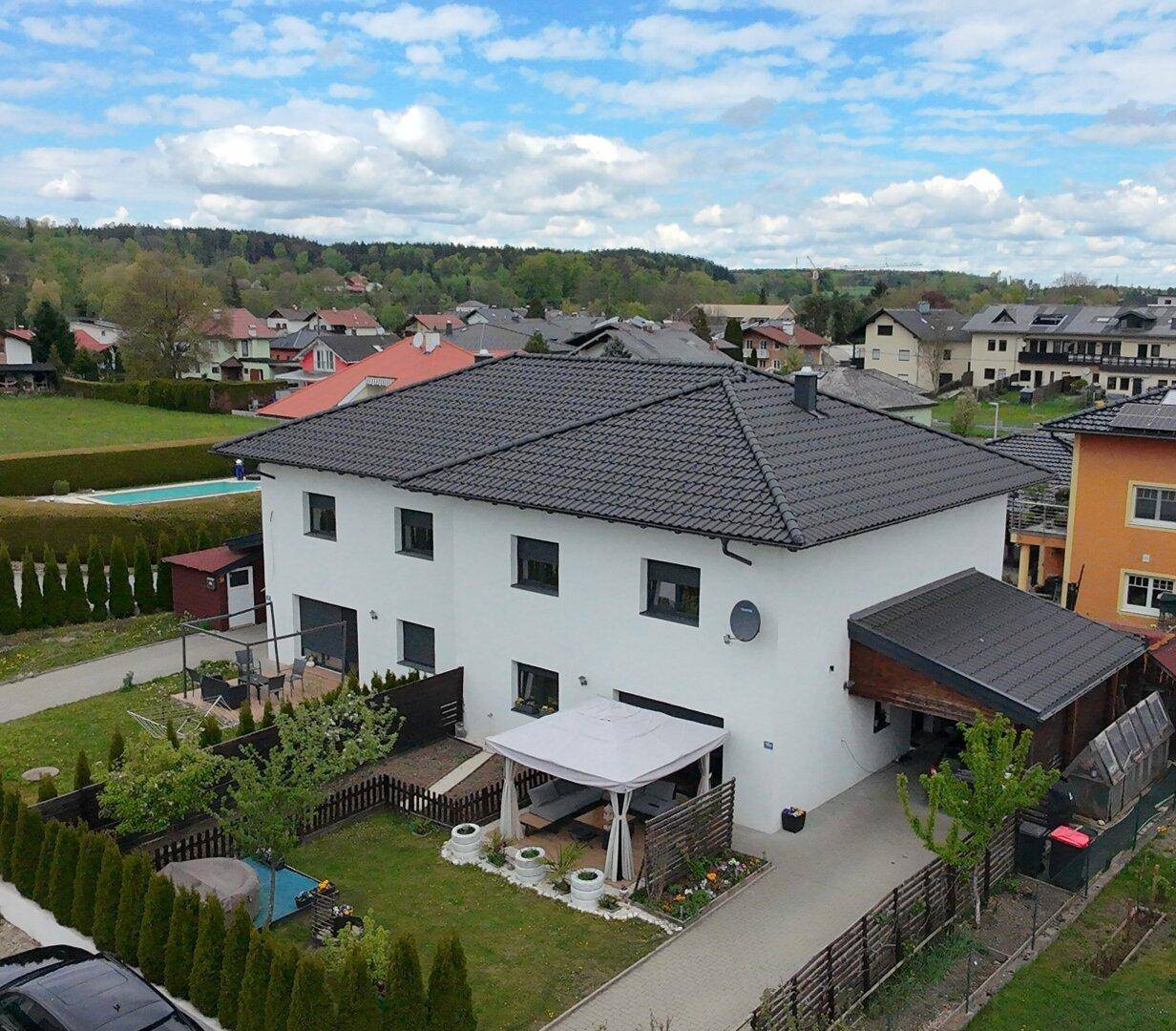 Freistehendes Einfamilienhaus mit gepflegtem Garten, Terrasse und Carport in ruhiger Wohngegend.