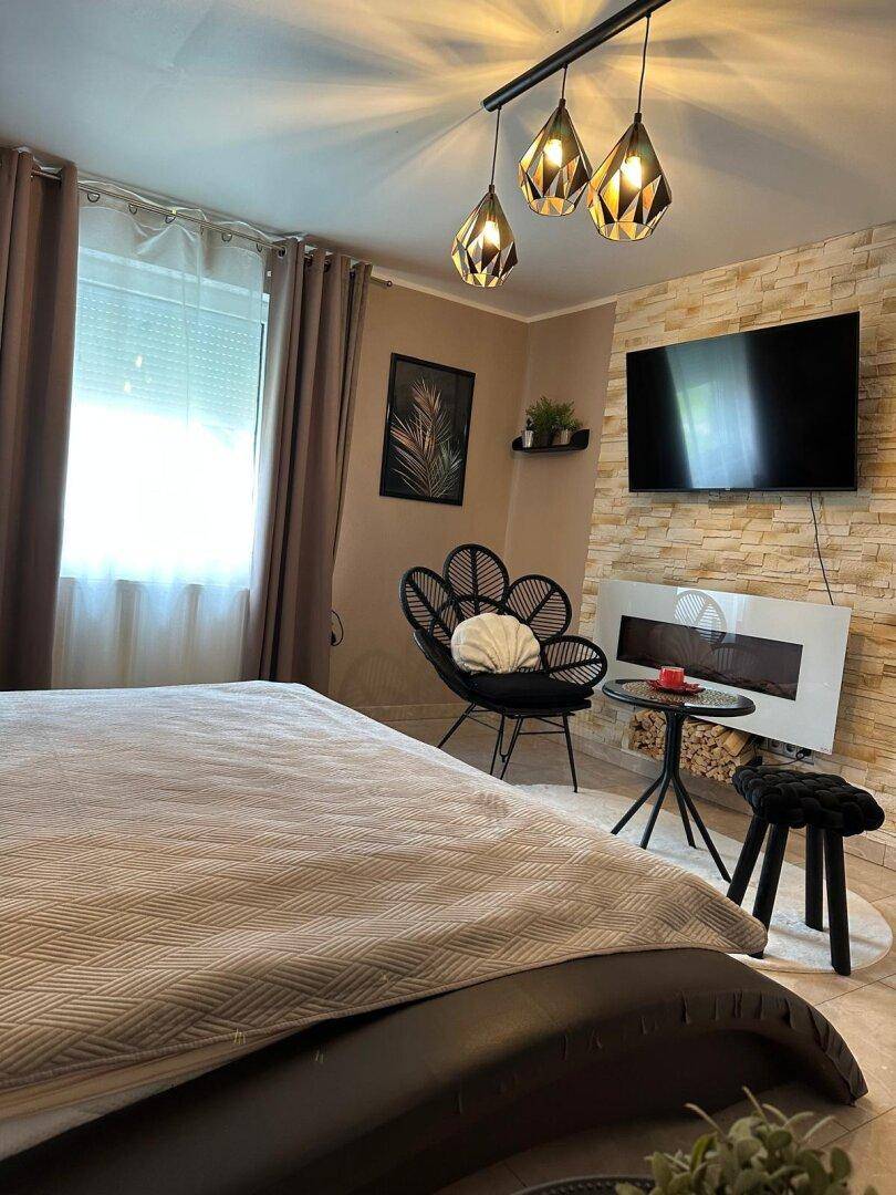 Modernes Schlafzimmer mit Steinwand-Akzent, großem Bett und stilvoller Beleuchtung.