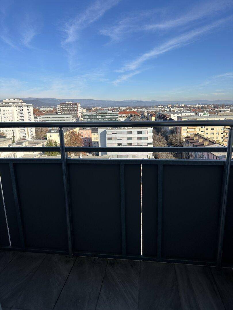 Balkon mit Metallgeländer bietet einen weiten Blick über die Stadt und die Umgebung.