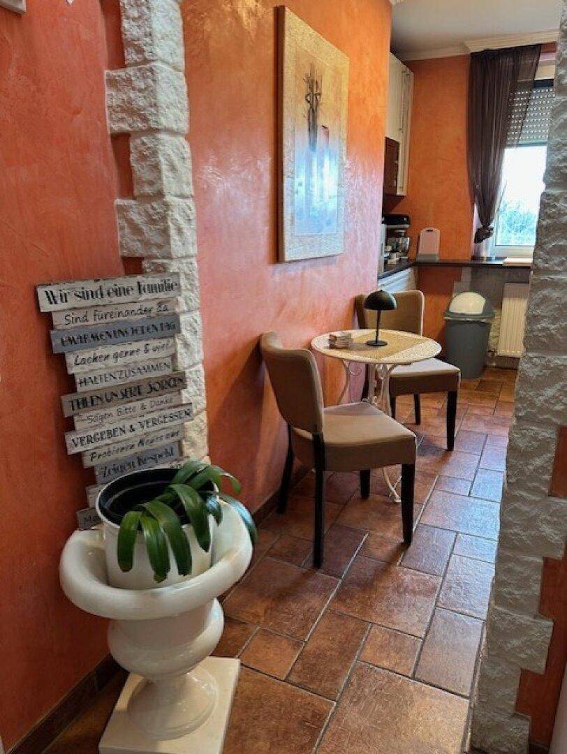 Küche mit Essbereich, Terrakotta-Fliesenboden und dekorativen Elementen.