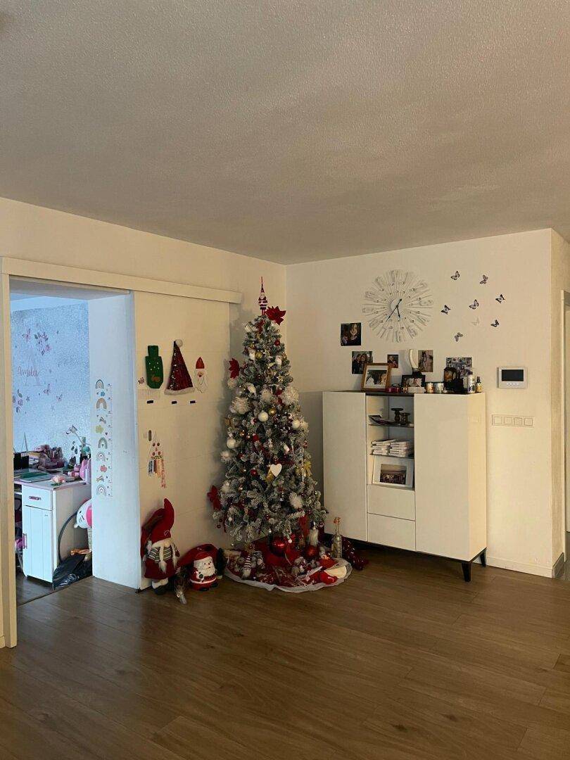 Heller Innenbereich mit Holzboden und festlicher Weihnachtsdekoration.