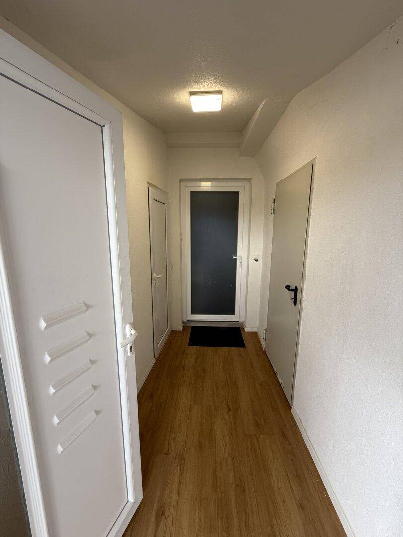 Heller Flur mit Laminatboden und mehreren Türen, die zu den verschiedenen Räumen führen.