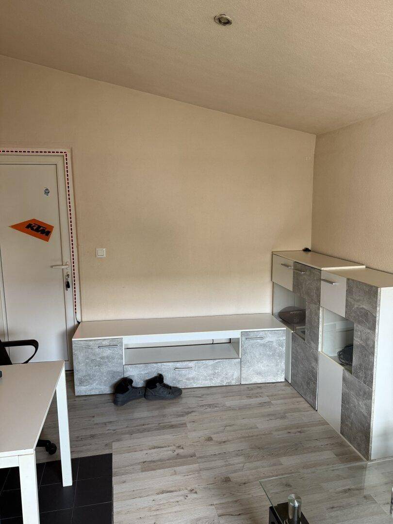Wohnbereich mit hellem Laminatboden und modernen Möbeln, die viel Stauraum bieten.