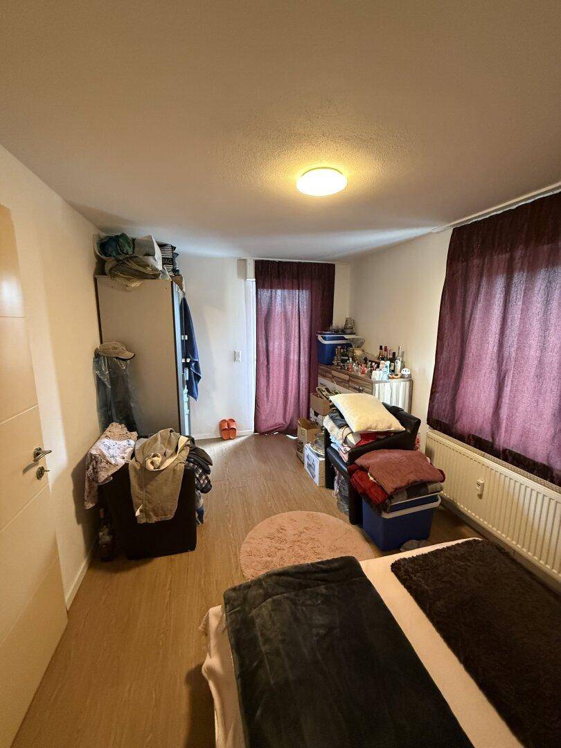 Schlafzimmer mit Doppelbett, hellem Boden und einem Kleiderschrank, der viel Stauraum bietet.