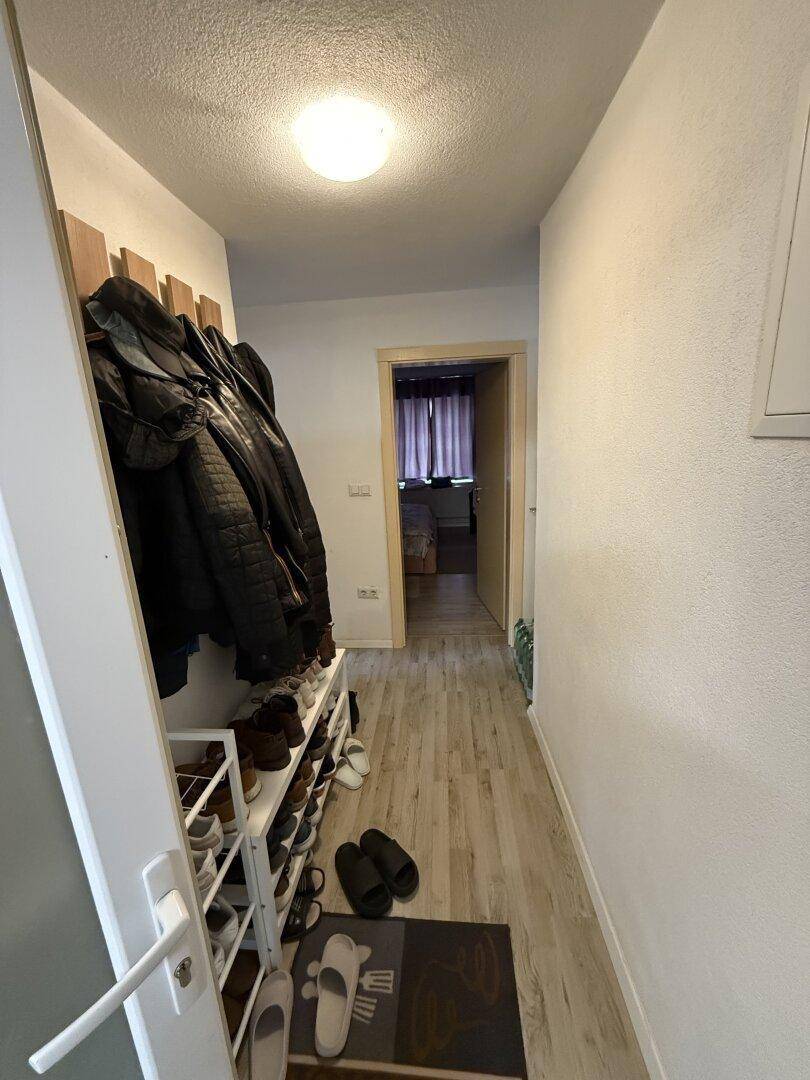 Heller Flur mit Garderobe, Schuhregal und hellem Laminatboden.