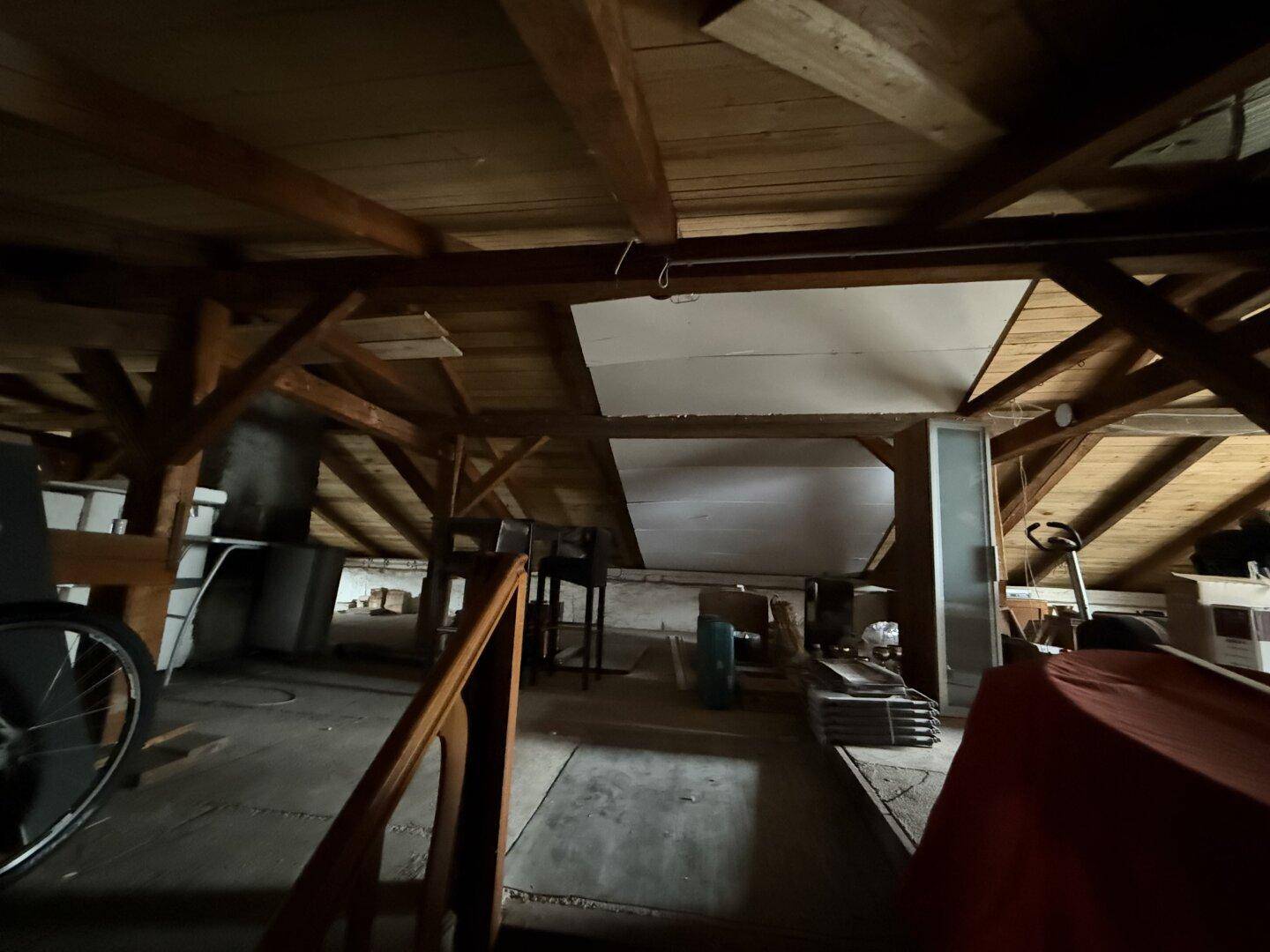 Geräumiger Dachboden mit sichtbaren Holzbalken und viel Stauraum.